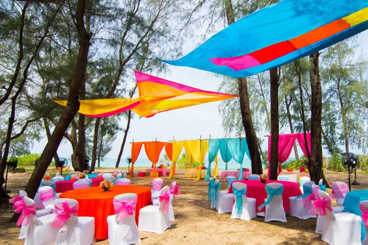 Outdoor wedding seating surrounded by colorful banners