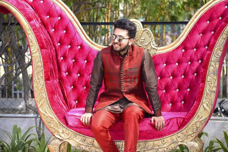 Hindu groom in sherwani sat on the ceremonial seat