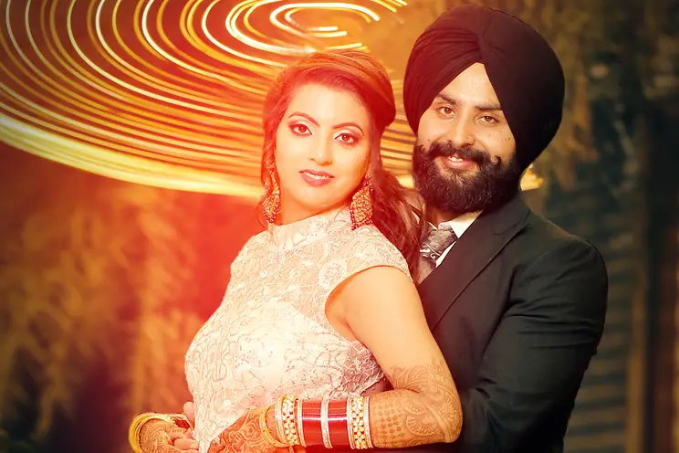 Sikh wedding couple embraced looking at camera