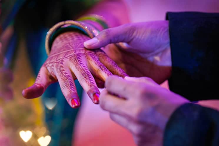 Groom putting wedding ring on brides finger