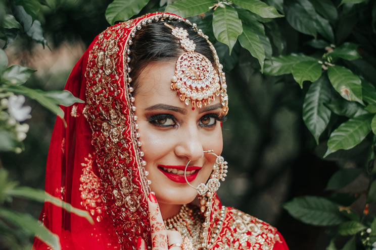 Sikh bride in wedding attire smiling at the camera